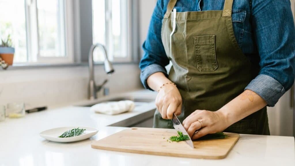 chef knife and cutting board in a first apartment kitchen on a budget
