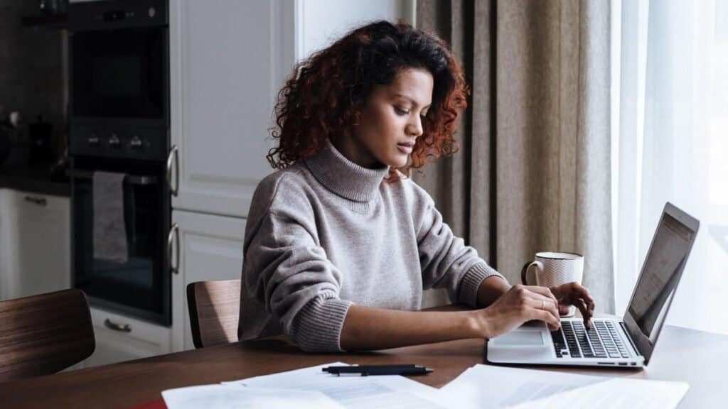 young renter reviewing a tenant screening report at a kitchen table
