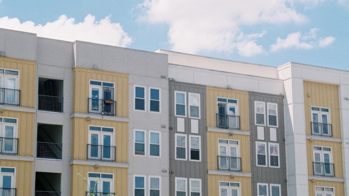 A multi-story apartment building exterior under a blue sky, representing a typical rental property covered by a renters insurance policy
