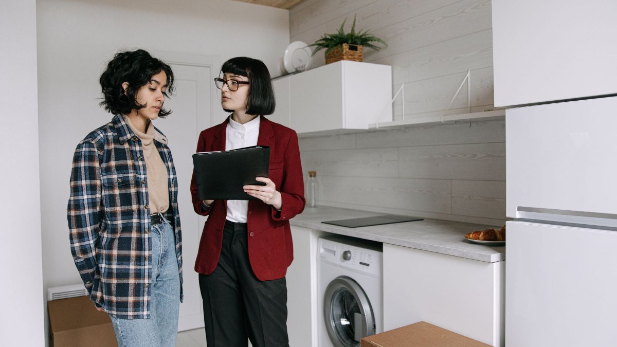 two people talking in an empty rental kitchen