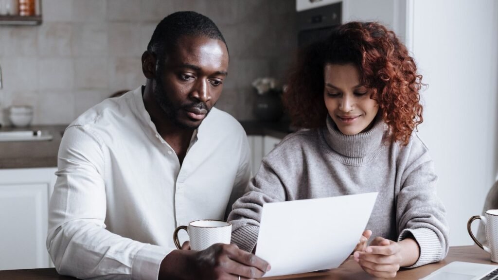 couple reviewing apartment fees and paperwork at a kitchen table