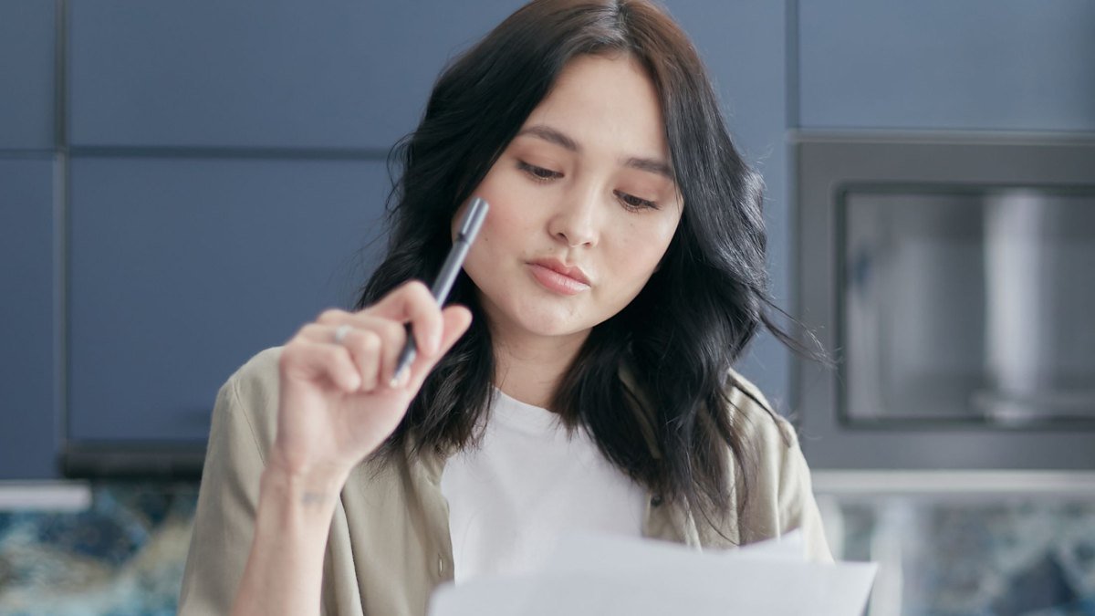 renter reading a lease document with a pen in hand