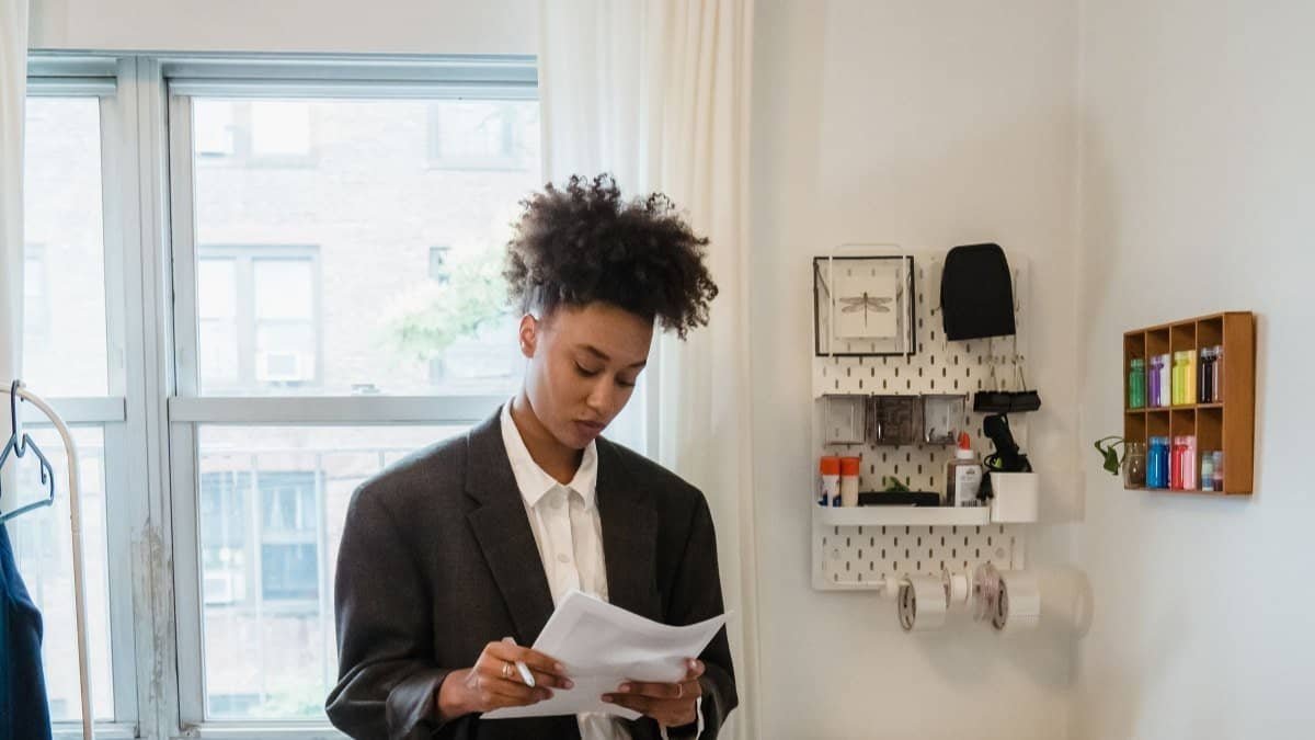 renter reading a screening report letter by an apartment window